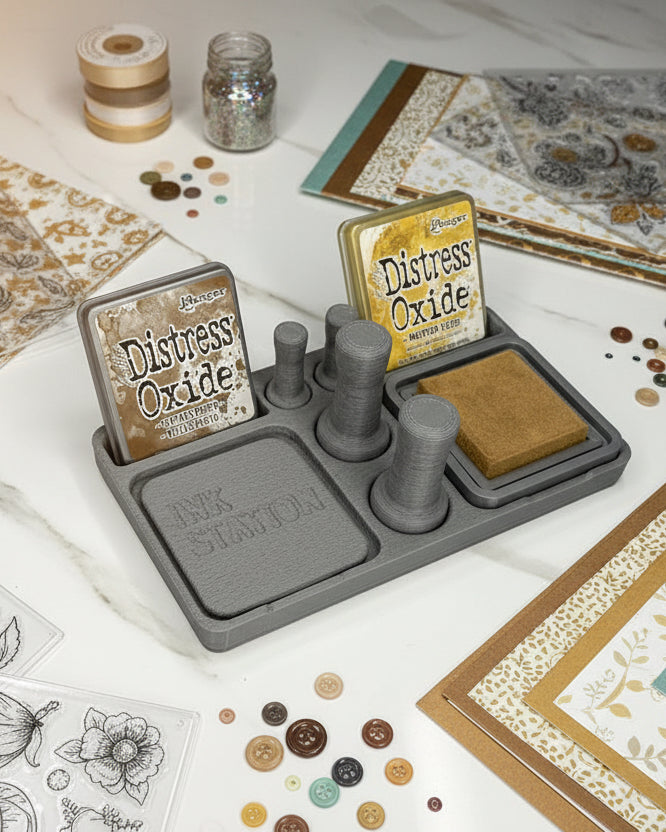 Ink station with 'Distress Oxide' ink pad and other tools on a white surface