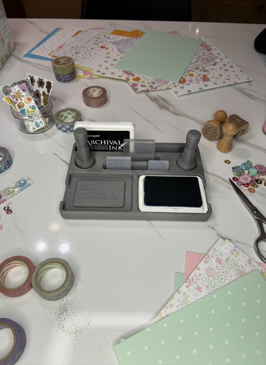 Gray ink pad and ink cartridge holder on a light marble surface