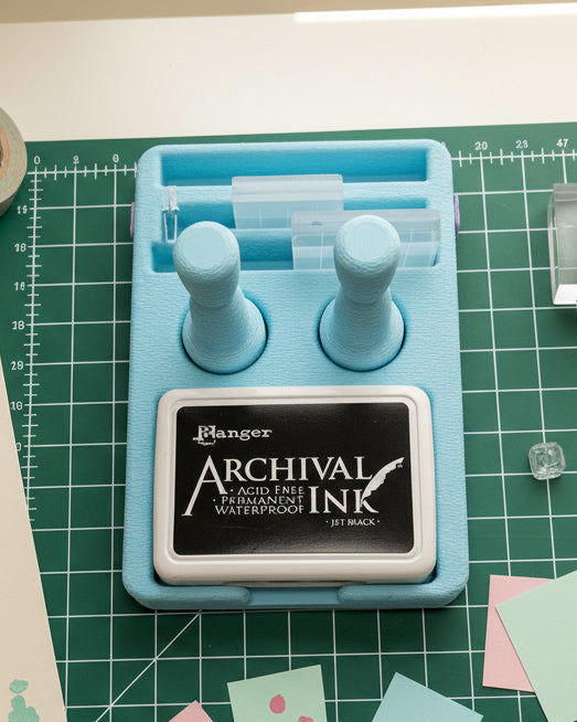 Archival ink pad with blue holder on a white background