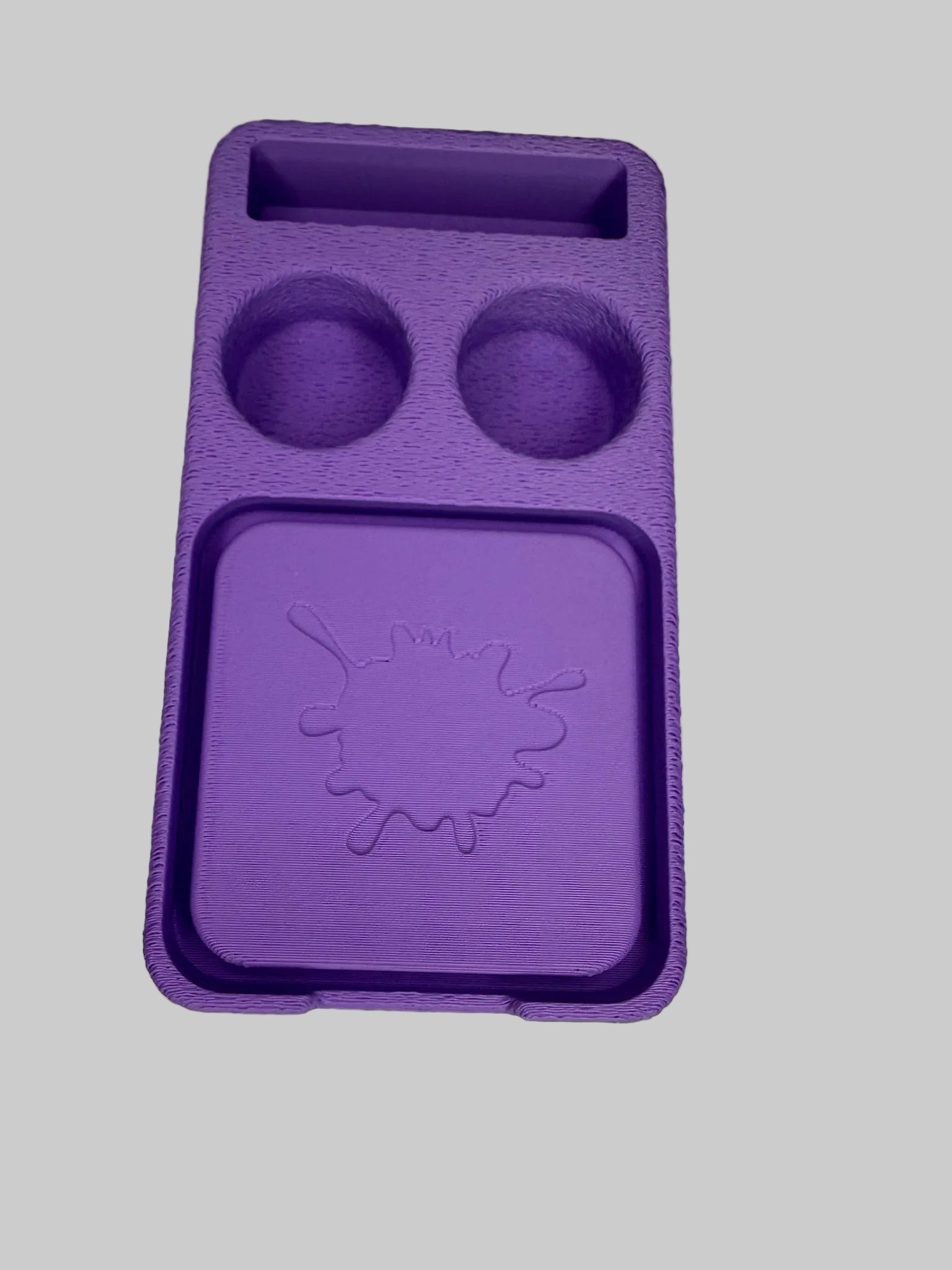 Purple silicone mold with two round cavities on a light-colored surface